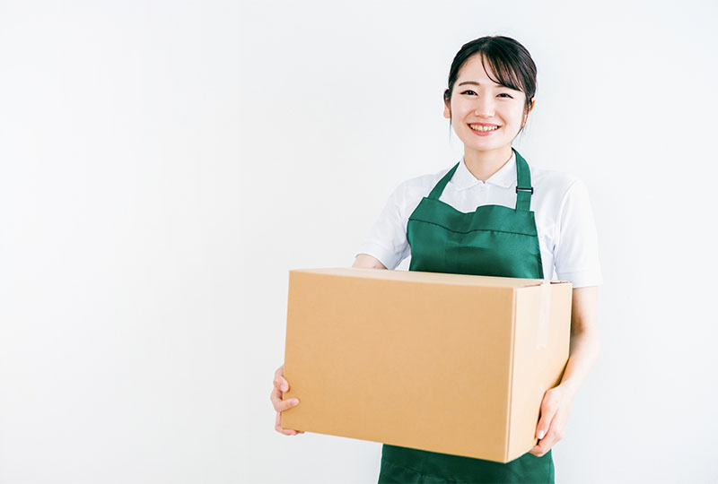 藤沢市でゴミ屋敷の片付けを依頼されて、ゴミを運び出す女性スタッフ。