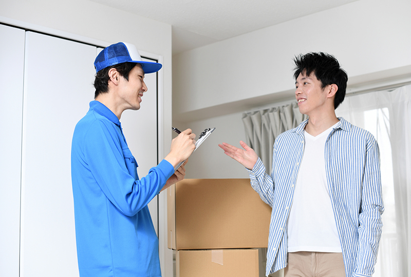 不用品回収エコスポットのスタッフと打ち合わせしている男性客